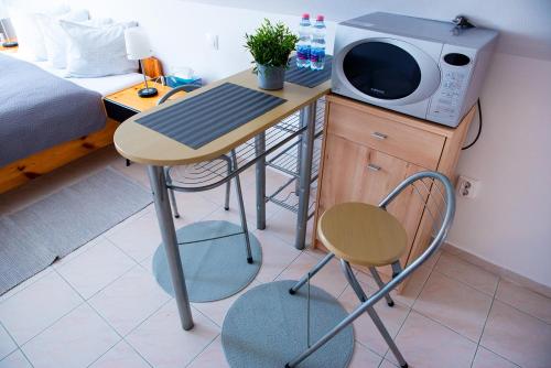 a table with a microwave and a chair in a room at Valentin ház in Szentendre