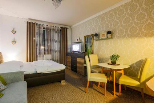 ein Hotelzimmer mit einem Bett, einem Tisch und Stühlen in der Unterkunft Apartmánový dom Fatrapark 1 s Wellness - Hlavná recepcia in Ružomberok