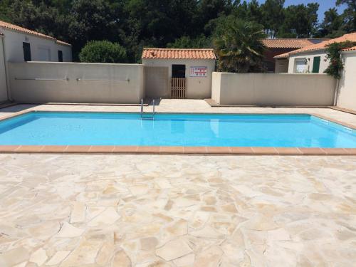 uma grande piscina num quintal com uma casa em La maisonnette des vacances em Saint-Georges-dʼOléron