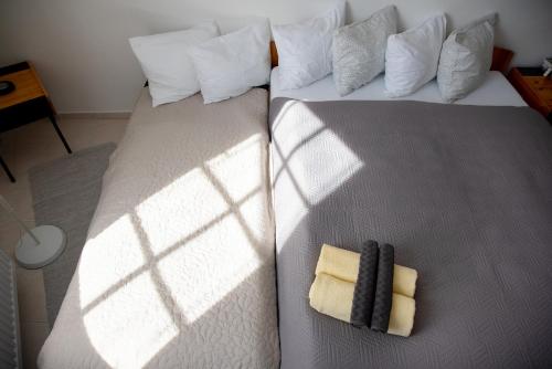 two beds in a bedroom with the sun shining on them at Valentin ház in Szentendre