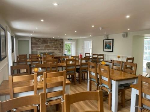 uma sala de jantar cheia de mesas e cadeiras de madeira em Conon Hotel em Dingwall