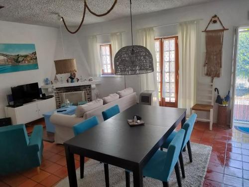 een woonkamer met een tafel en blauwe stoelen bij Casa de Praia in Vila do Conde