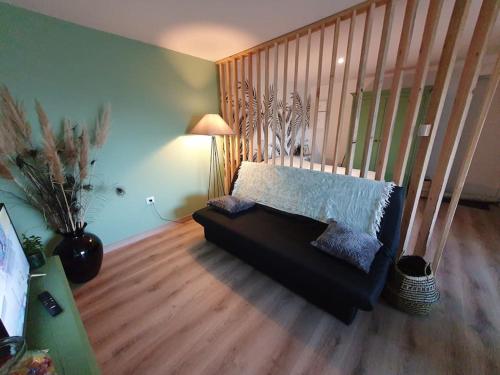 a living room with a couch in a room at Charmant appartement au calme in Saint-Romain-la-Motte