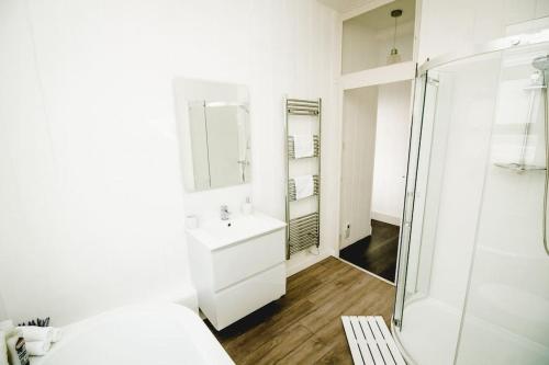 a white bathroom with a sink and a shower at Seaview Beach House in Norwich