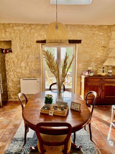 a dining room with a wooden table and chairs at Le Mas Réolais in Saint-Sève