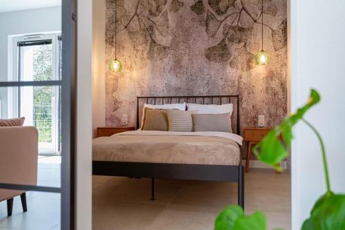 ein Schlafzimmer mit einem Bett und einer Wand mit Bäumen in der Unterkunft Apartament J&T Mrągowo in Mrągowo