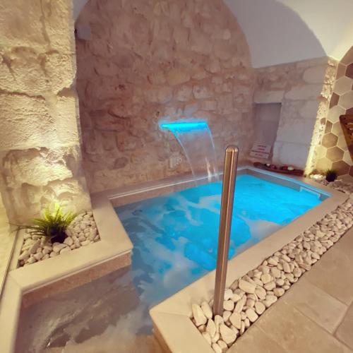 a swimming pool in a house with a water feature at Luxury Suite Alfieri in Martina Franca
