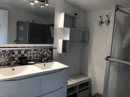 a bathroom with a white sink and a mirror at La Cabane de peche de la Cotiniere in Saint-Pierre-dʼOléron