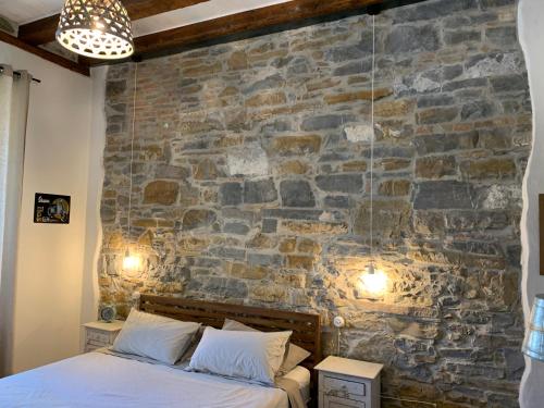a bedroom with a stone wall and a bed at Santorio 5 Apartment in Trieste