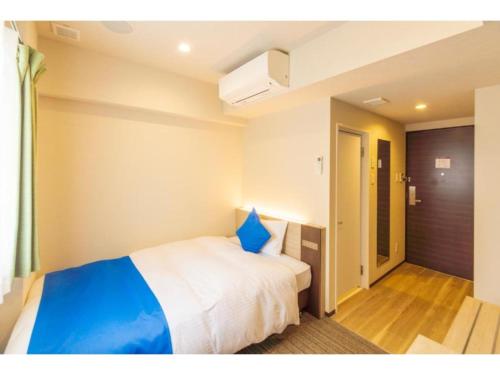 um quarto com uma cama grande e uma almofada azul em HOTEL LANTANA Naha Kokusai Street - Vacation STAY 65441v em Naha