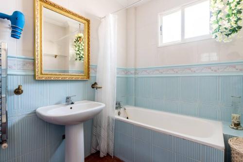 a bathroom with a sink and a tub and a mirror at Star's House Sevilla.Con piscina,10 min de Sevilla in Valencina de la Concepción