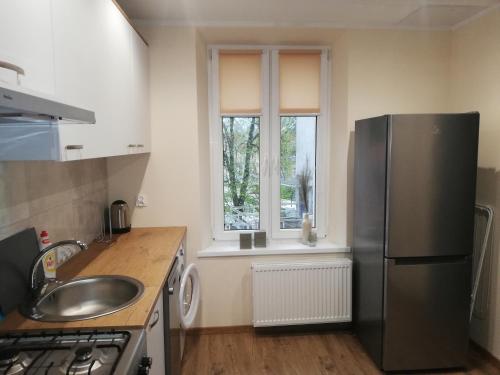 eine Küche mit einem Kühlschrank aus Edelstahl und einer Spüle in der Unterkunft Mieszkanie na Mazurach in Giżycko