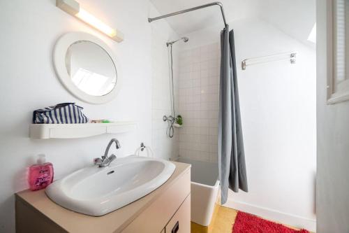 Baño blanco con lavabo y espejo en Petite maison bourg de La Trinite sur Mer - 4 à 6 couchages, en La Trinité-sur-Mer