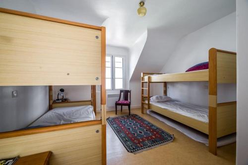 1 dormitorio con 2 literas y 1 silla en Petite maison bourg de La Trinite sur Mer - 4 à 6 couchages, en La Trinité-sur-Mer