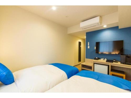 Cette chambre comprend 2 lits et une télévision à écran plat. dans l'établissement HOTEL LANTANA Naha Kokusai Street - Vacation STAY 65442v, à Naha
