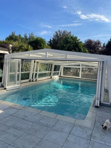 - un pavillon au-dessus d'une piscine dans une maison dans l'établissement Le Chai Maison de charme pour tribu joyeuse, au Château-dʼOléron