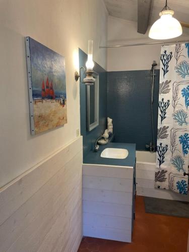 La salle de bains est pourvue d'un lavabo et d'une peinture murale. dans l'établissement Le Chai Maison de charme pour tribu joyeuse, au Château-dʼOléron