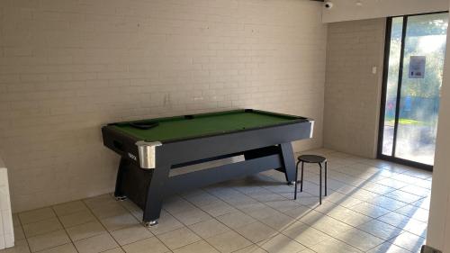 a ping pong table in a room with a green top at Pemberton Hostel - note - Go to Gloucester Motel Reception for check in - Backpackers 88 days farm work available in the Manjimup and Pemberton Region in Pemberton