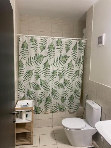 a bathroom with a toilet and a shower curtain at King Abdullah Economic City Apartment - KAEC شقة بمدينة الملك عبدالله الاقتصادية- حي الواحة in King Abdullah Economic City