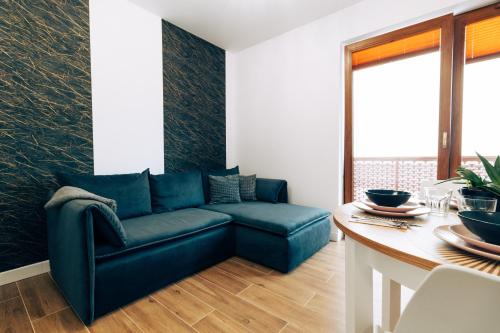a living room with a blue couch and a table at Apartament Marbud 2 przy Aquaparku Reda in Rumia