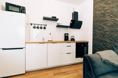 a kitchen with white cabinets and a black appliance at Apartament Marbud 2 przy Aquaparku Reda in Rumia
