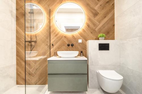 a bathroom with a toilet and a sink and a mirror at Willa La Maddalena ALLDAYHOLIDAY Mielno in Mielno