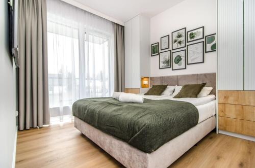 a bedroom with a large bed and a large window at Willa La Maddalena ALLDAYHOLIDAY Mielno in Mielno
