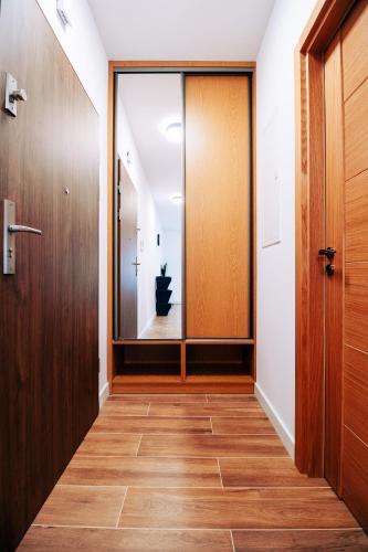 a hallway with a glass door and wooden floors at Apartament Marbud 2 przy Aquaparku Reda in Rumia