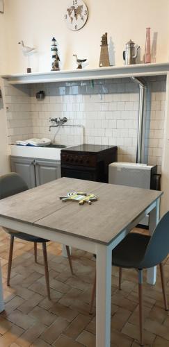 une cuisine avec une table et des chaises dans une cuisine dans l'établissement Chez fabienne, à Cayeux-sur-Mer