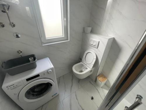 a bathroom with a washing machine and a toilet at Studio Galija in Poreč