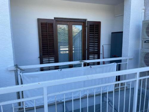 a balcony with a wooden door and a window at Studio Galija in Poreč