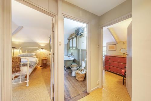 a bedroom with a bed and a bathroom at Ford Cottage in Corscombe