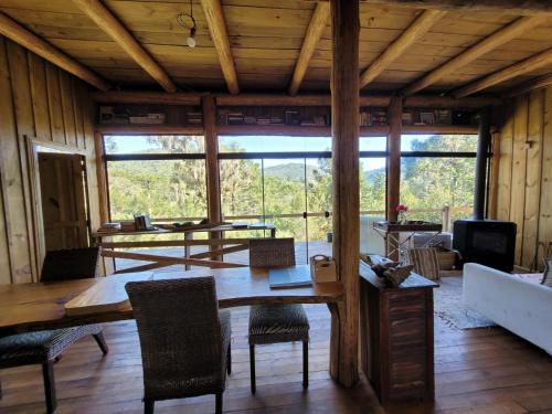 a living room with a wooden table and chairs at Yahoo ecolodge in Bocaina do Sul