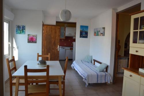 een keuken en eetkamer met een tafel en een bank bij Petite maison bord et vue mer, 55 m2 in Martigues