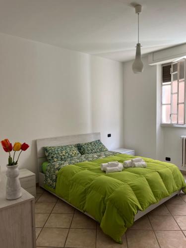 Un dormitorio con una gran cama verde con toallas. en Cà del Fili, en Lenno