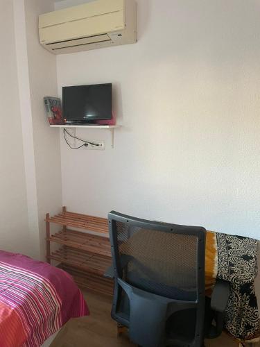 a tv sitting in a room with a bed and a wall at Habitación privada en Rincón in Rincón de la Victoria