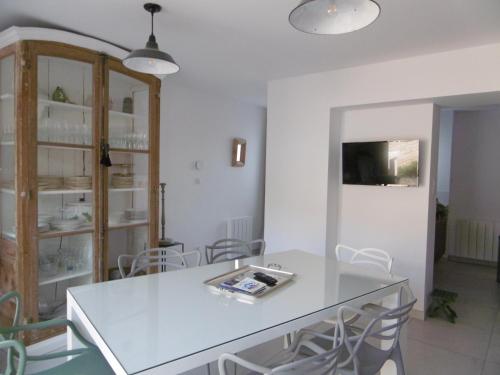 une salle à manger avec une table et des chaises blanches dans l'établissement La Brijolie 450m de la plage La Biroire, à Saint-Pierre-dʼOléron