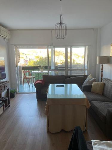 Habitación privada en Rincón في رينكون دي لا فيكتوريا: غرفة معيشة مع أريكة وطاولة