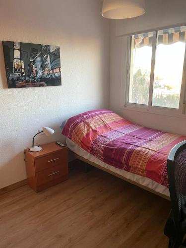 a bedroom with a bed and a lamp and a window at Habitación privada en Rincón in Rincón de la Victoria
