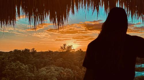 a person standing in front of a sunset at Costa Nube in Caye Caulker