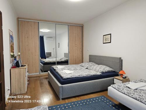 a bedroom with two beds and a mirror at GAJ Apartment - Air condition - Free Parking in Krakow