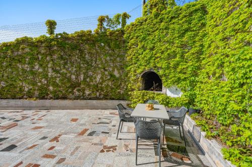 a table and chairs in front of a green wall at Apartmani Marko in Omiš