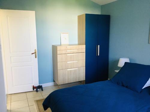 a bedroom with a blue bed and a cabinet at Les Amarres belle maison 1,5km de la plage in Saint-Denis-dʼOléron