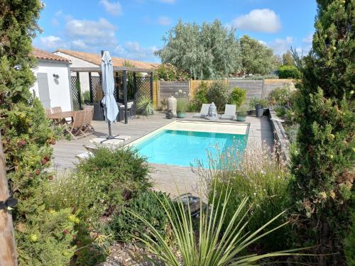 サン・ドニ・ドレロンにあるVilla Clara, 600m de la mer, piscineの傘付きの庭園内のスイミングプール