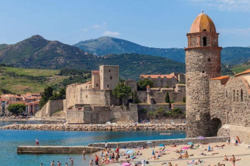 - un groupe de personnes sur une plage à côté d'un château dans l'établissement Duplex terrasse, Collioure, à Collioure