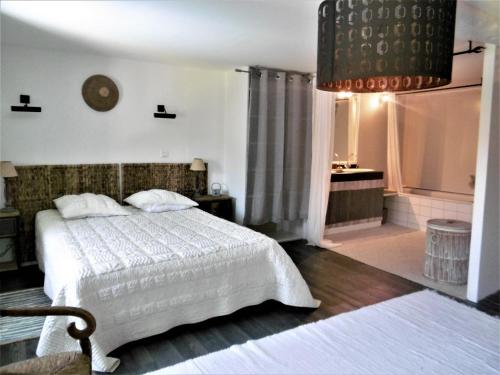 1 dormitorio con cama blanca y ventana en Le Logis du Breuil - Piscine privee, en Saujon