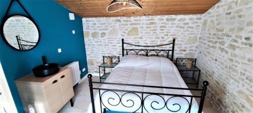 1 dormitorio con cama y pared azul en Villa Ohana proche centre-ville, en Le Château-dʼOléron