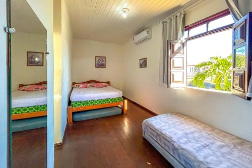 a room with two beds and a window at Casa com piscina e churrasq em Lauro de Freitas BA in Lauro de Freitas