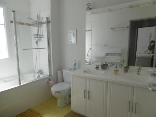 une salle de bain avec un lavabo, des toilettes et un miroir dans l'établissement L Azuree en front de mer, à Le Port-des-Barques