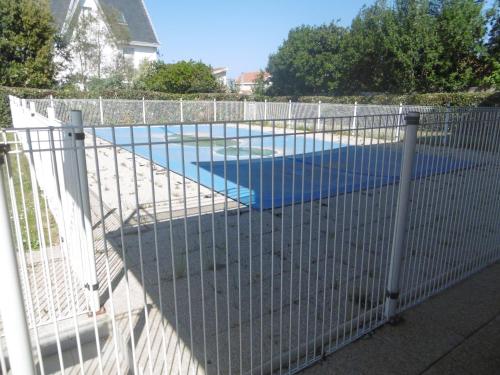 une clôture avec une piscine derrière dans l'établissement L Azuree en front de mer, à Le Port-des-Barques